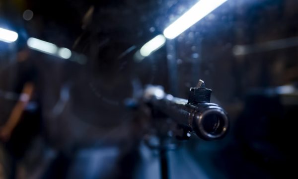 cs 1.6 步枪第一人称视角，准星对准远处木箱后的人影，画面色调偏沙黄